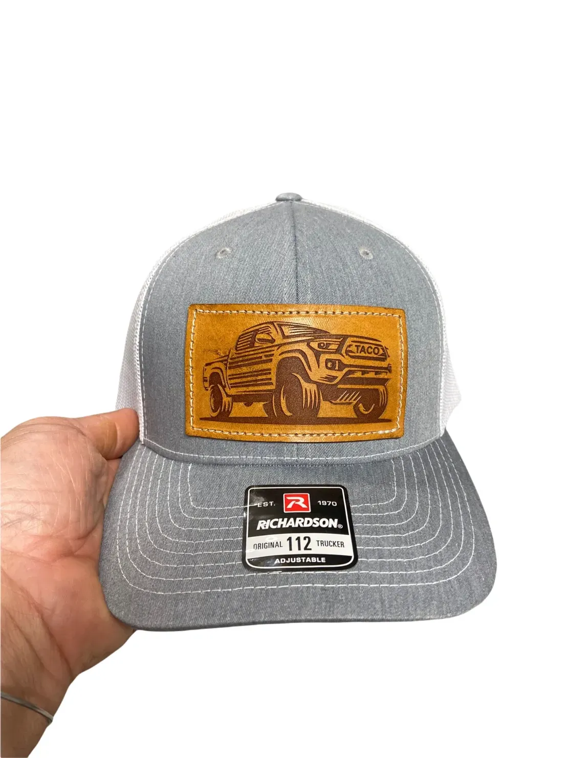 Hand holding truck-embroidered gray cap