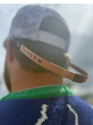 Man wearing cap with "FREEDOM" strap