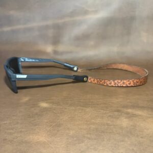 Stylish sunglasses on brown surface