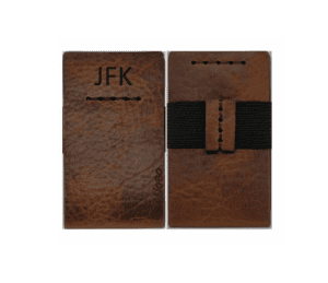 Brown leather wallet with a black ribbon tied around it, and the initials "JFK" written on it